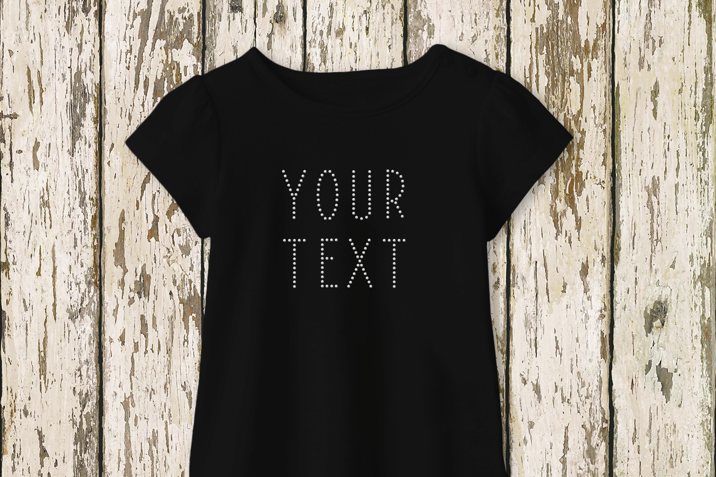 A black tee with the phrase "YOUR TEXT" made out of clear rhinestones.