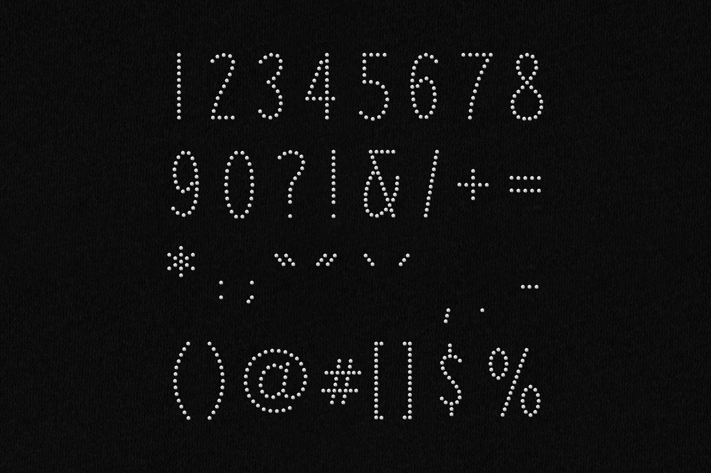 Numbers and punctuation made out of clear rhinestones on a black background in an art deco style.