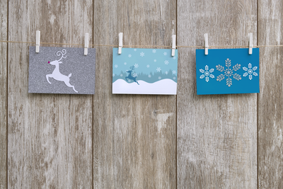 Three cards. One with a reindeer, one with a winter scene, and one with a trio of snowflakes.