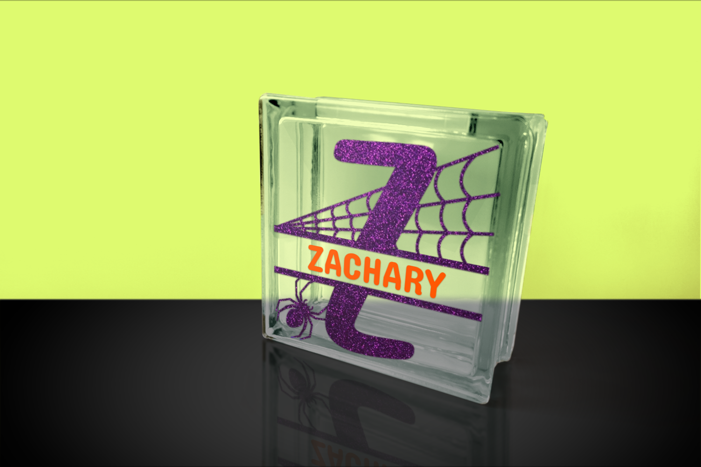 Glass block with the letter Z with spiderwebs behind it and a crawling spider. A split is in the middle of the letter.