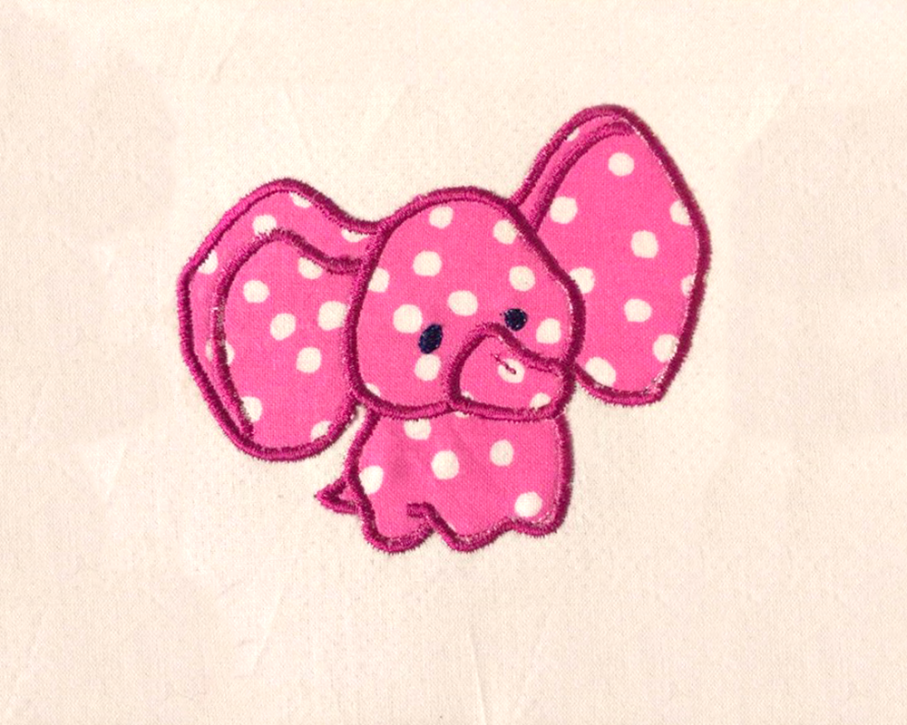 Applique of a little baby stuffed elephant on a muslin piece of fabric. The applique fabric is hot pink with white polkadots.