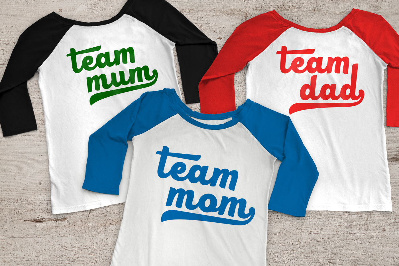 Three raglan tees sit on a wood background. Each has baseball style letters and they say "Team mum," "Team mom," and "Team dad."