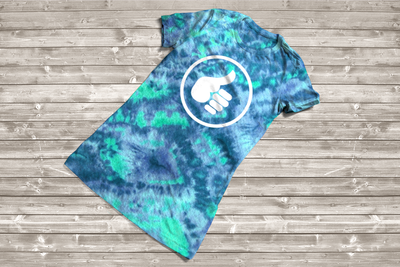 Tye-dyed tee with a thumb giving the hitchhiking gesture inside of a circle.