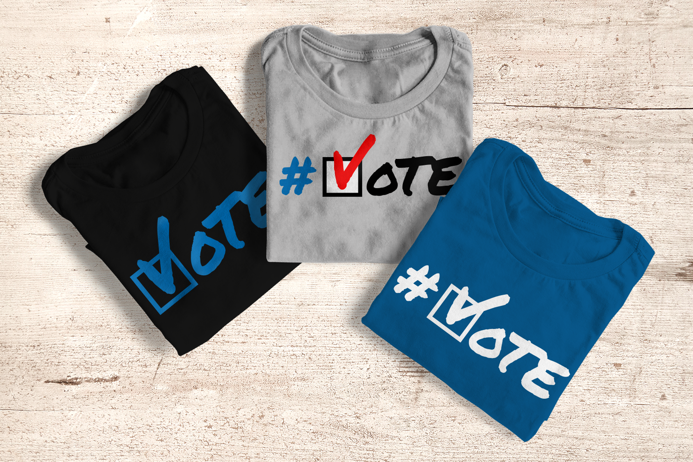 Three folded shirts. Each has the word VOTE with the V looking like a checkmark and a box behind it.