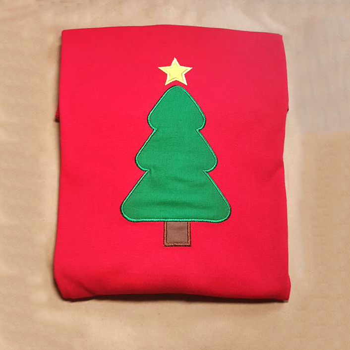 Red folded shirt with an applique Christmas tree.