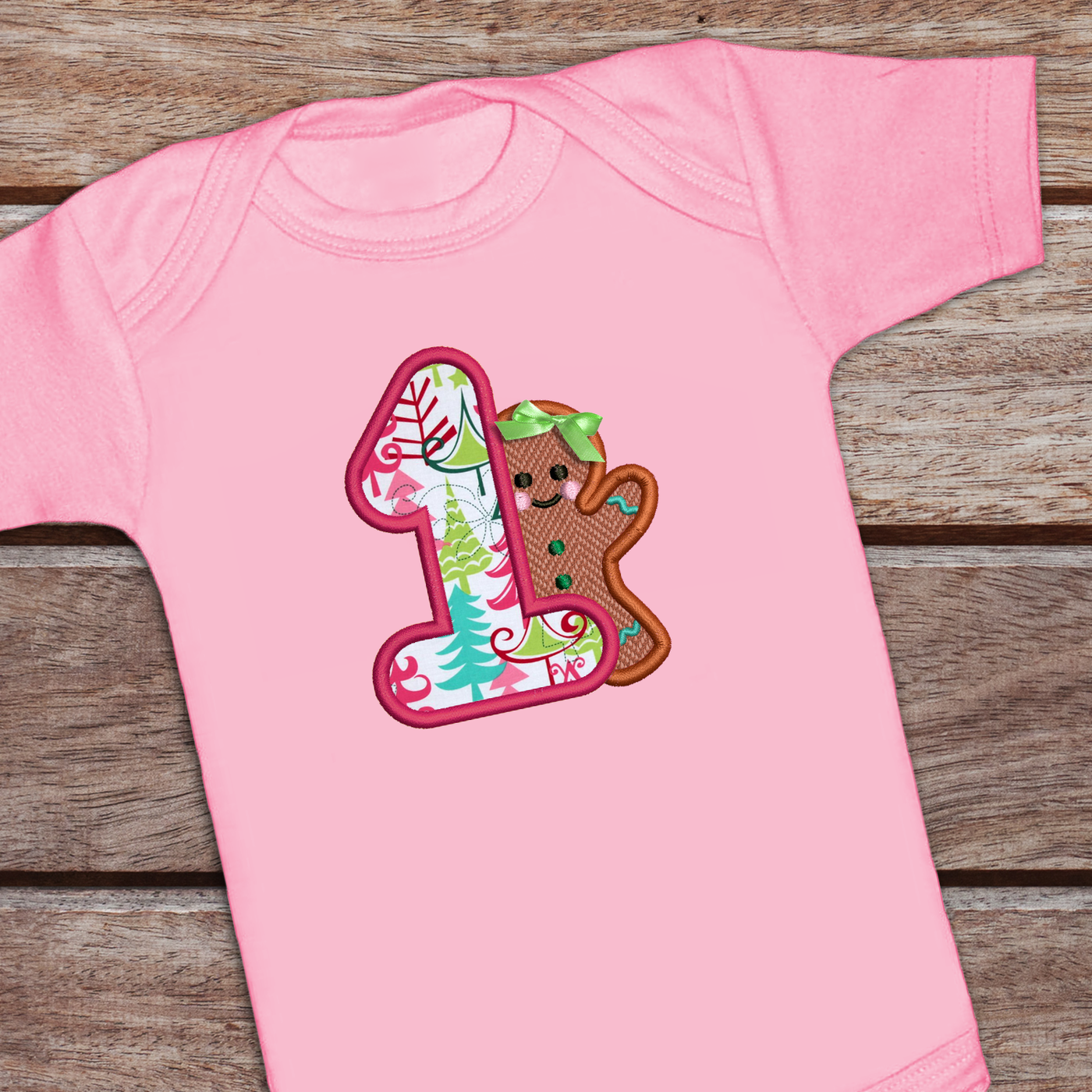 Onesie with a large applique 1 and a gingerbread girl with a real bow.