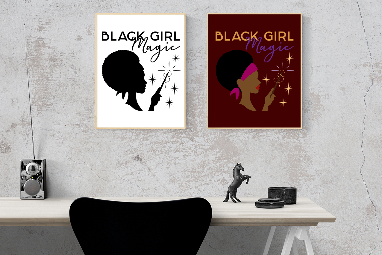 Two framed posters hang above a desk. The poster on the left is white with a black design, the poster on the right is dark red with a multicolor design. Both feature a black woman with a scarf and afro waving a wand. She is shown in profile view from the neck up and the hand from the wrist up. Around the wand are stars and a swirl. Above are the words "Black Girl Magic."
