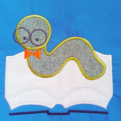 Applique worm crawling on a book and wearing glasses and a bow tie.