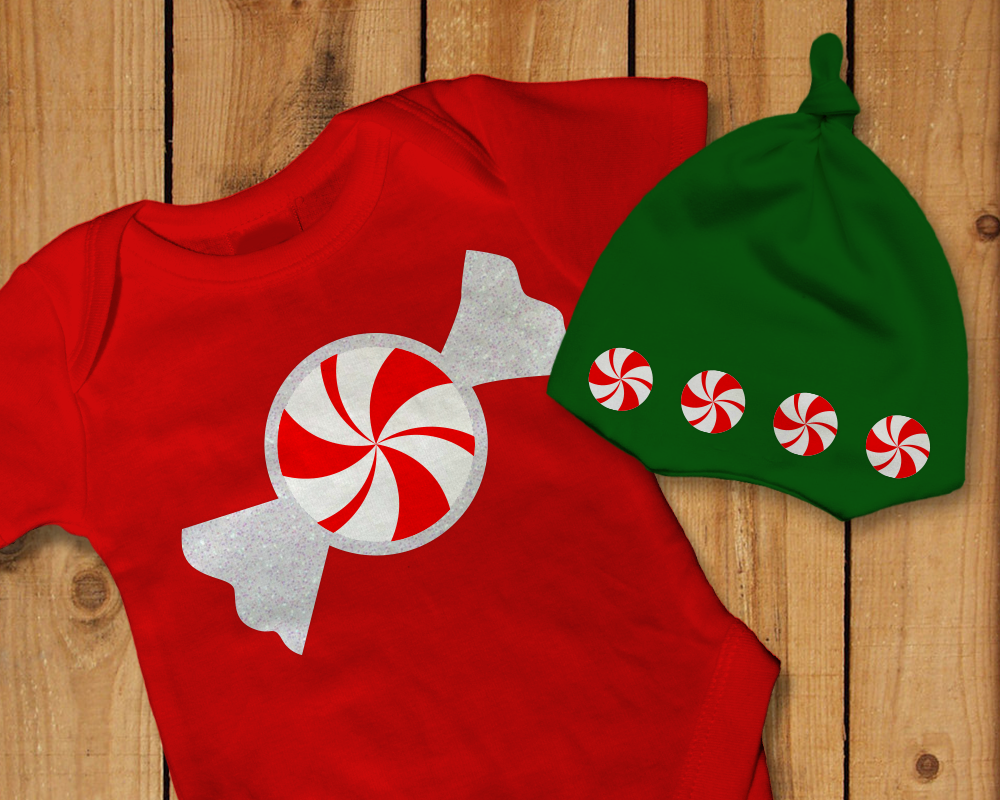 A baby onesie and knotted baby cap. Each has a design with a round red and white swirl peppermint.