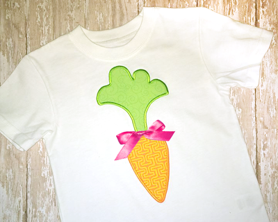 A white shirt with a cute carrot applique. There is a hot pink satin bow added.