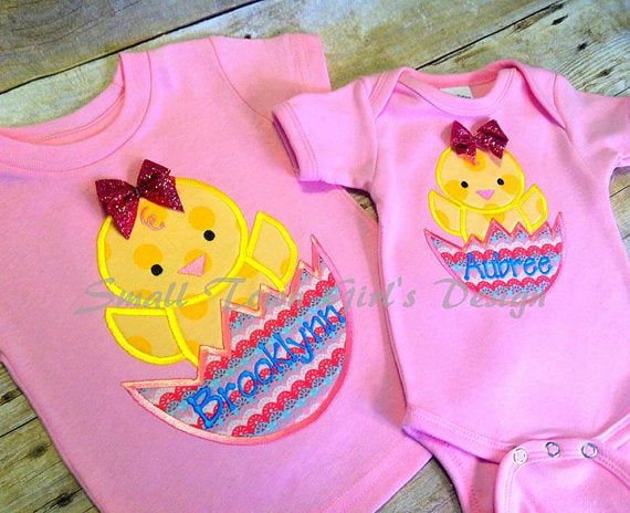 A child's shirt and a baby onesie, each with an applique design of a chick popping out of a cracked egg.