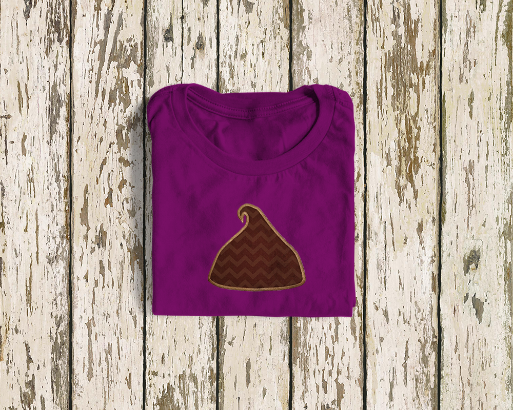 A folded shirt with an applique design of a large chocolate chip.