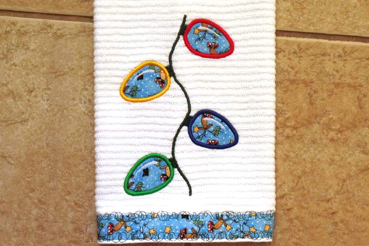 Applique of 4 holiday lights on a wavy string