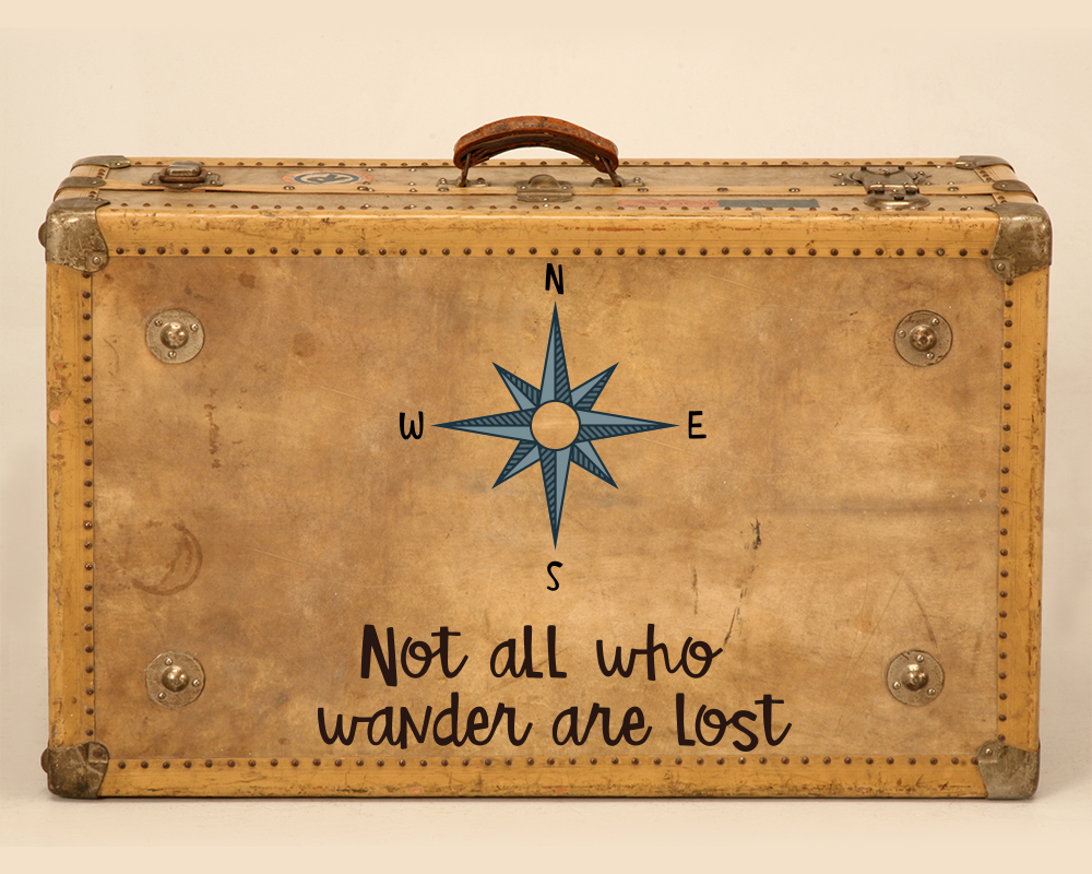 An old suitcase with a compass rose and the words "Not all who wander are lost"