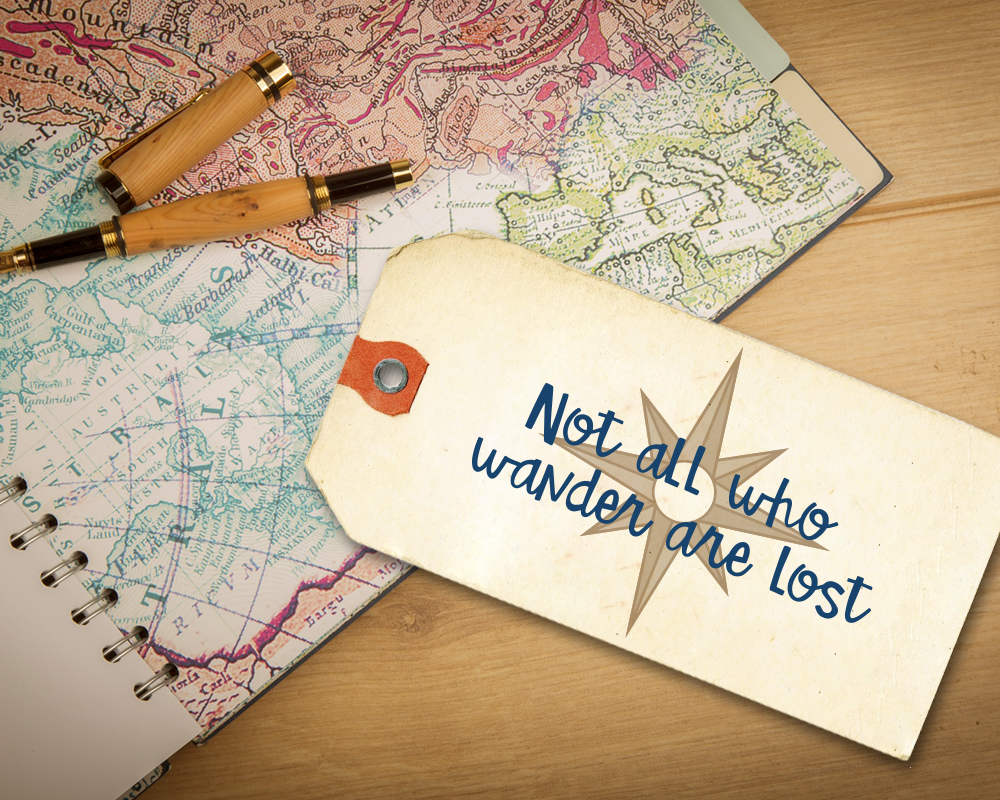 A map with a luggage tag that says "Not all who wander are lost" with a compass rose behind.