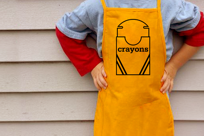 A white child wearing a yellow apron with an open box of crayons design.