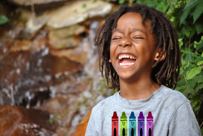 Laughing black boy with a shirt with a crayon design