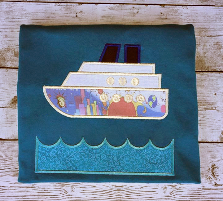 A dark blue piece of fabric with the applique of a cruise ship and waves below. There is space between the ship and the waves for adding your own text.