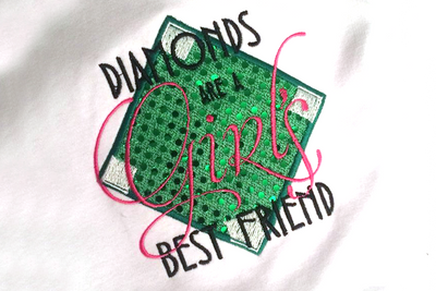 Applique design of a baseball diamond. On top is embroidered the words "Diamonds are a Girl's best friend."