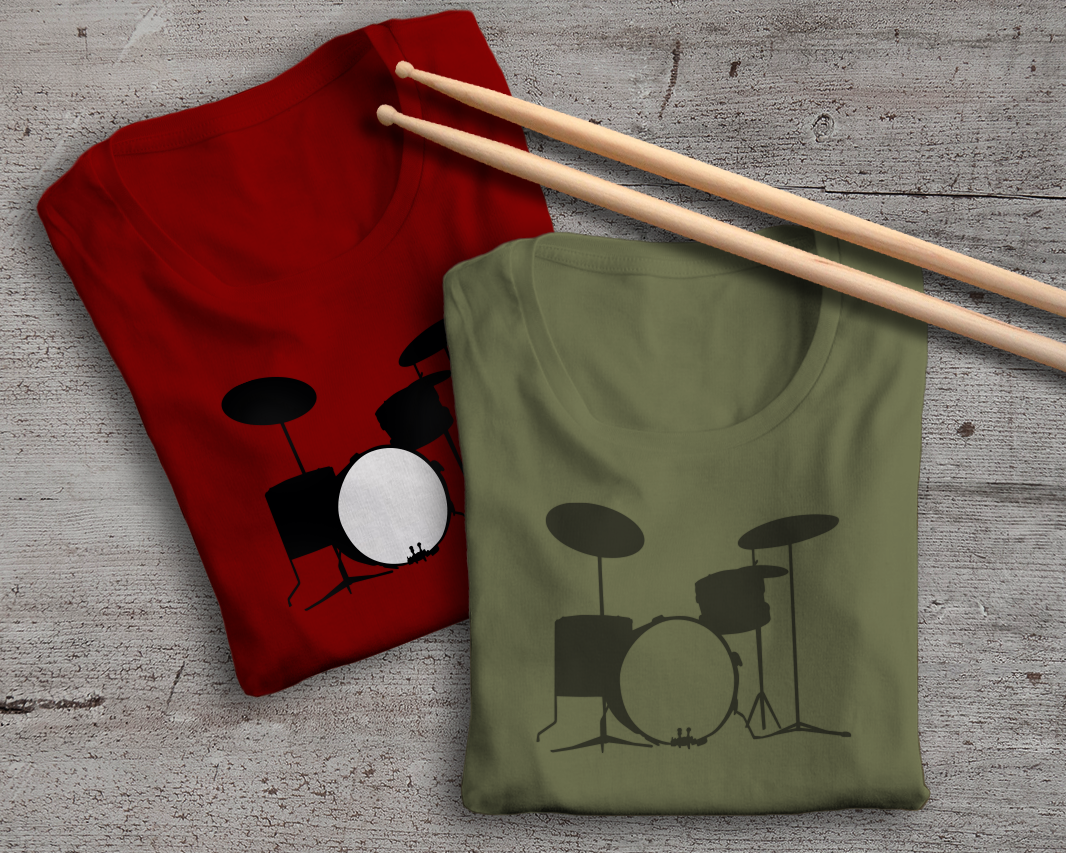 Two folded tees. Each has the design of a drum kit. Laying on top are a pair of drumsticks.