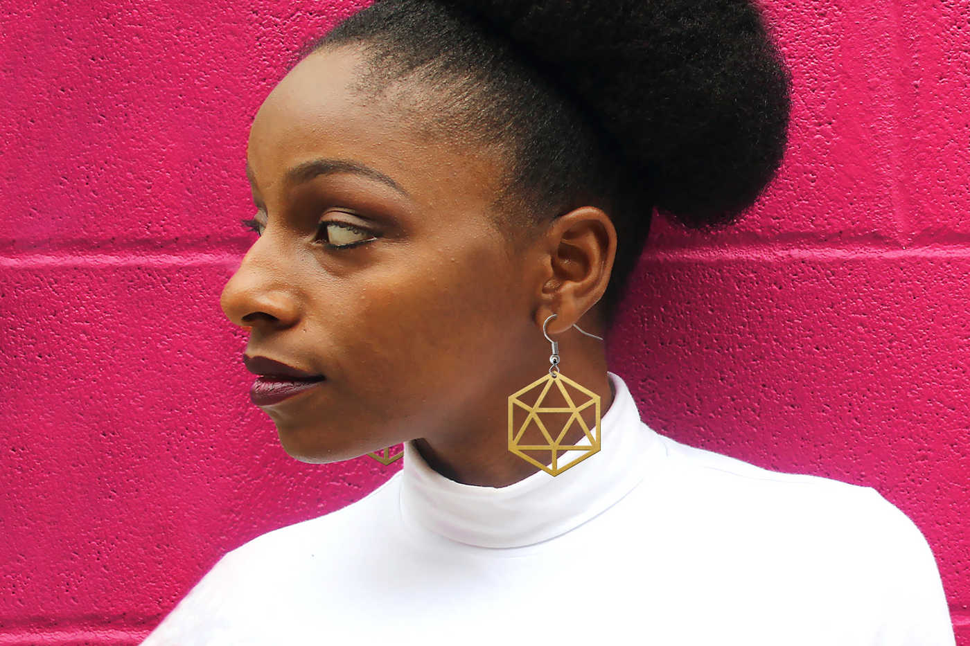 Black woman wearing a pair of earrings made from the cut file