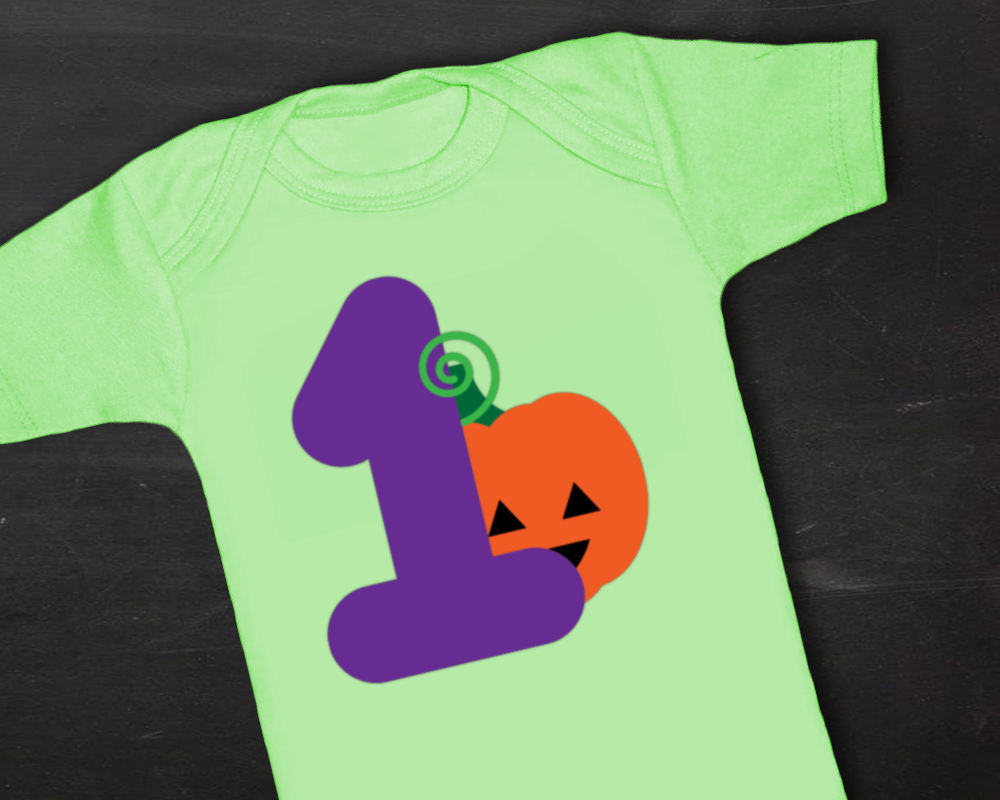 Green baby onesie with a large 1 on it. Behind the number is a cute jack-o-lantern.