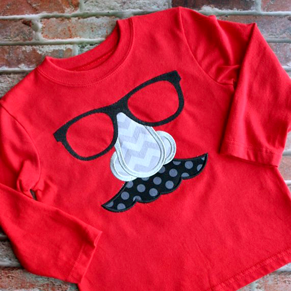 Applique on a shirt of Groucho Marx style joke glasses with a large nose and mustache.
