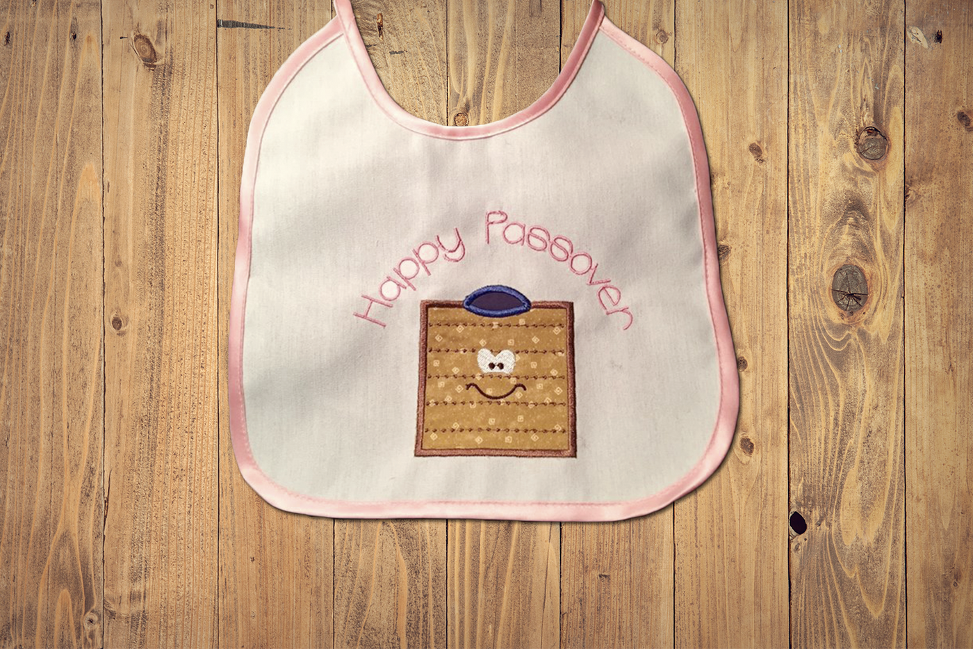 Applique of a cartoon matzo with a yarmulke. Above it says "Happy Passover"