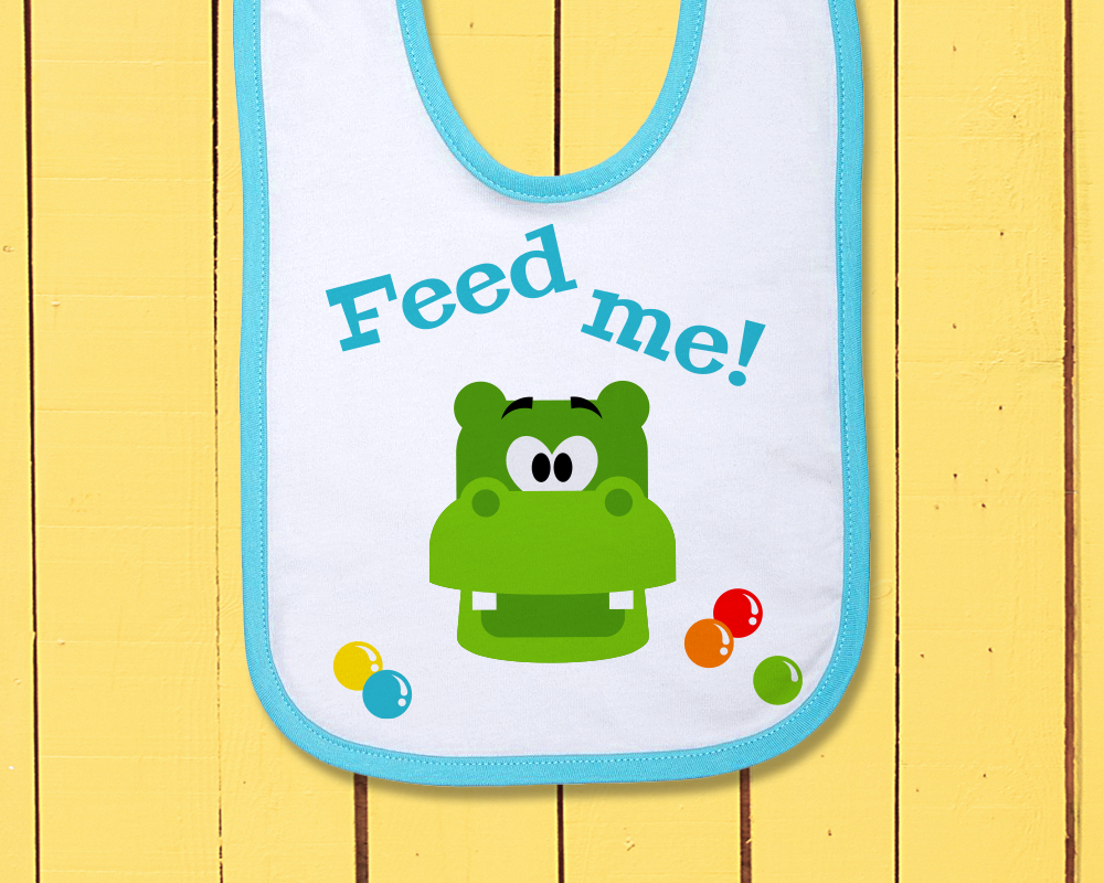 A bib with a green hippo face surrounded by marble.s Above it says "Feed me!"