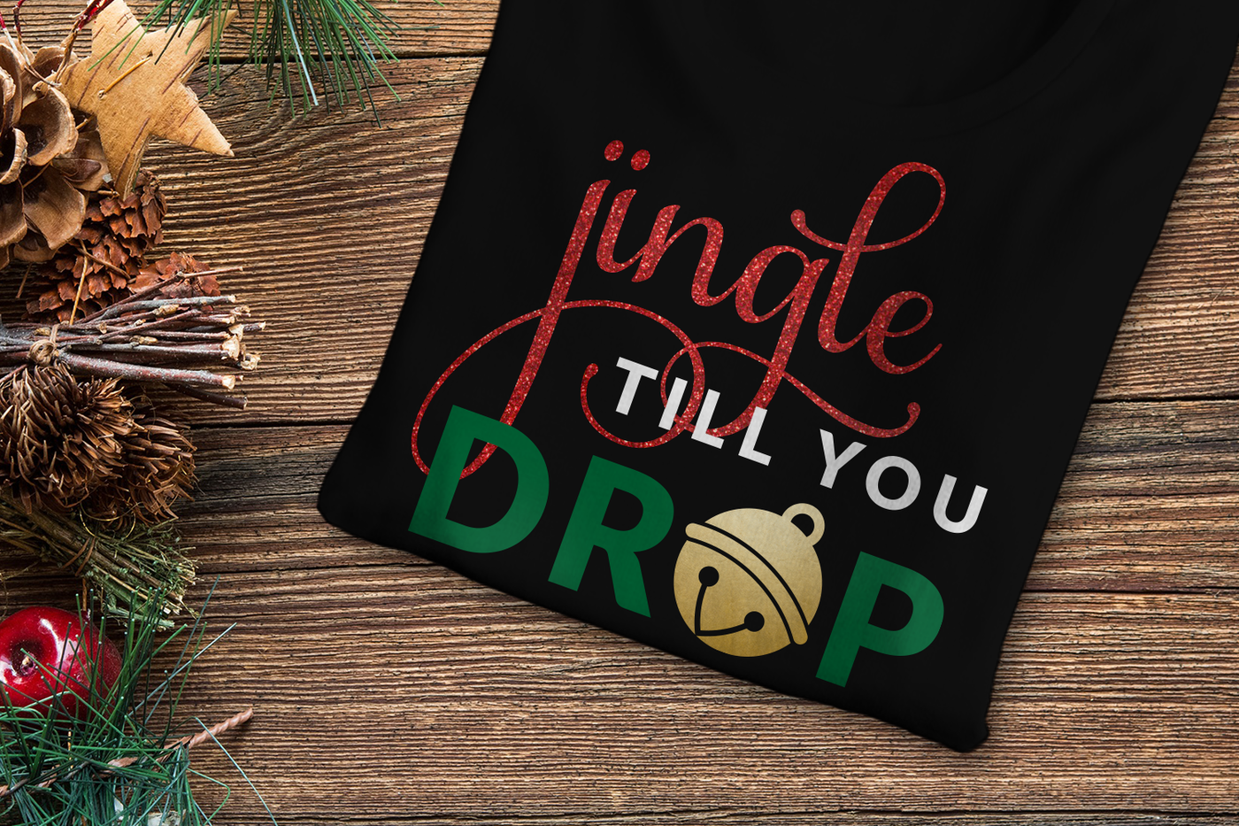 Black folded tee with a design that says "jingle till you drop." There is a round bell in place of the last O.