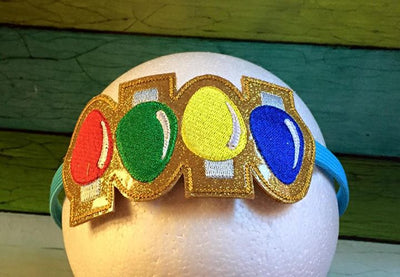 A headband with a slider in the hoop design on top that has 4 Christmas light bulbs in different colors