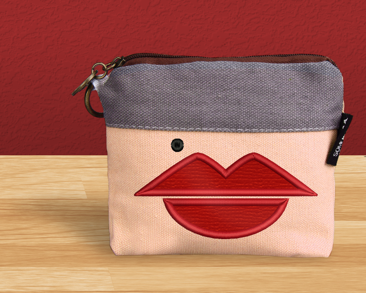 Makeup bag with cartoony applique lips and a beauty mark.