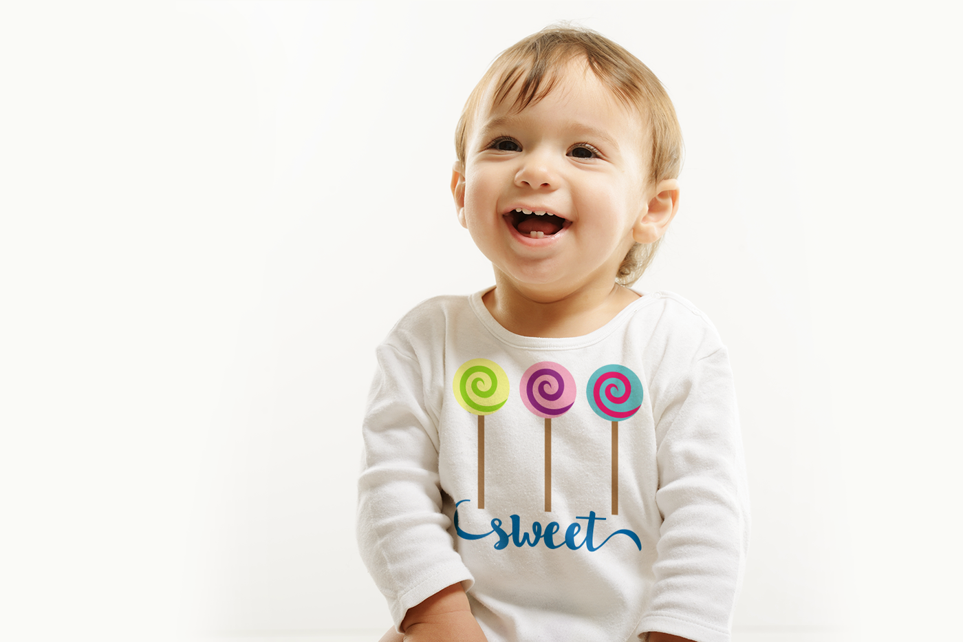 White baby wearing a shirt with three swirled lollipops that says "sweet" below