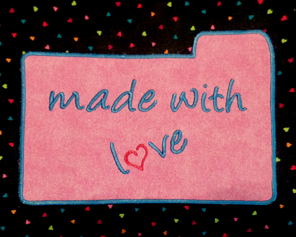 Applique of recipe card that says "made with love." There is a heart in place of the O.