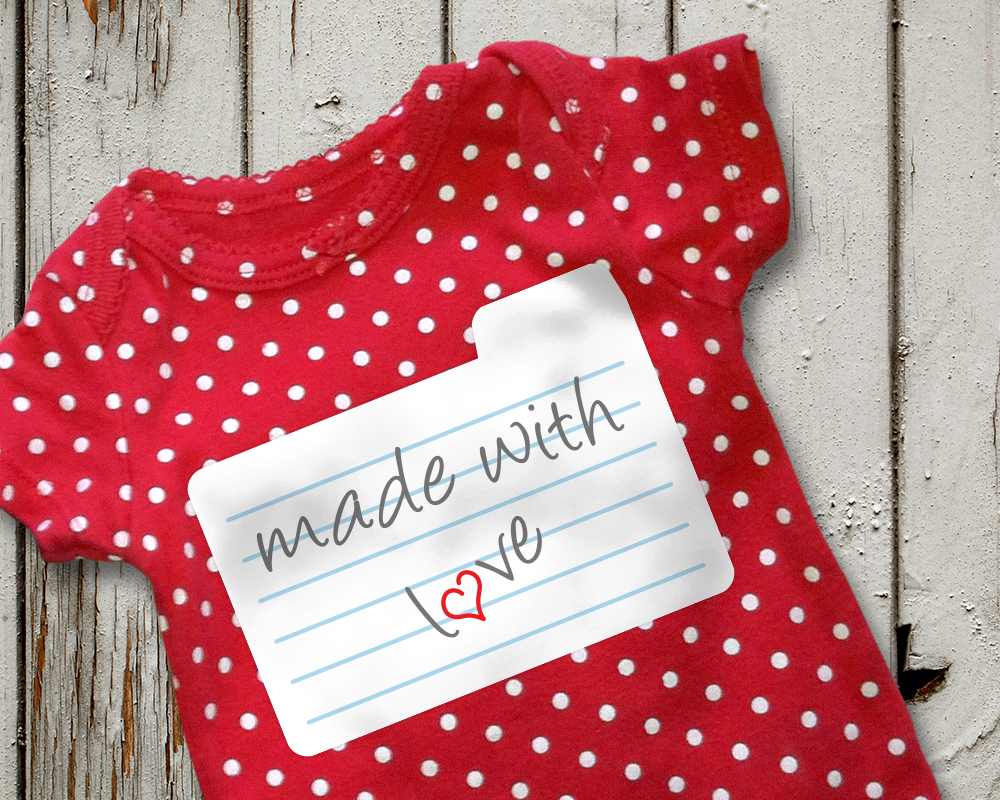 Baby onesie with a recipe card design. The card says "made with love" and a heart is in place of the O.