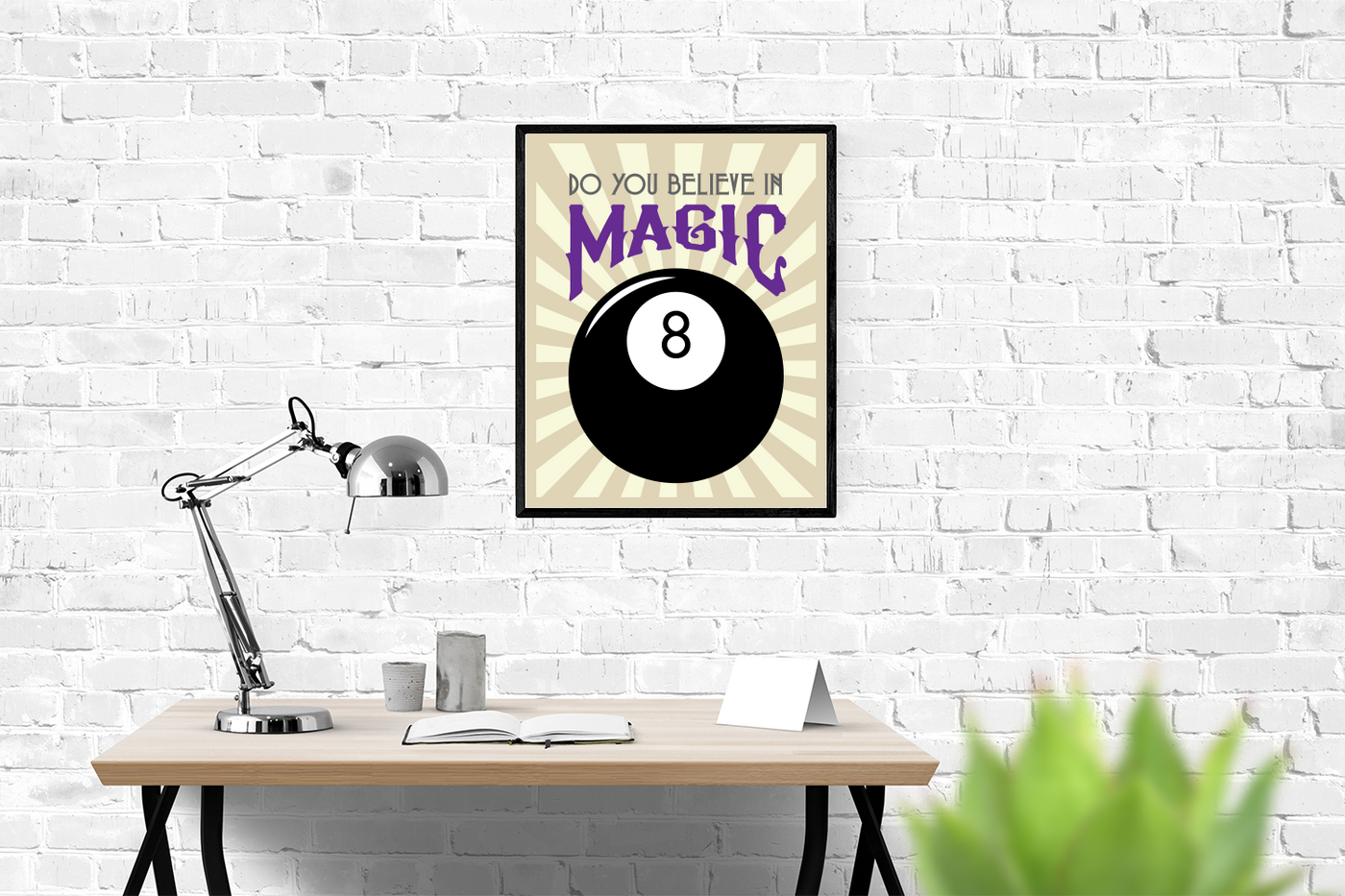 Framed poster above a desk. The poster has a large 8 ball and says "Do you believe in Magic"