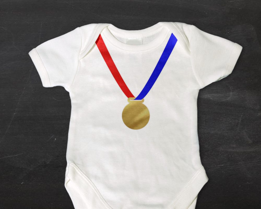 Baby onesie with a gold medal on a ribbon design.
