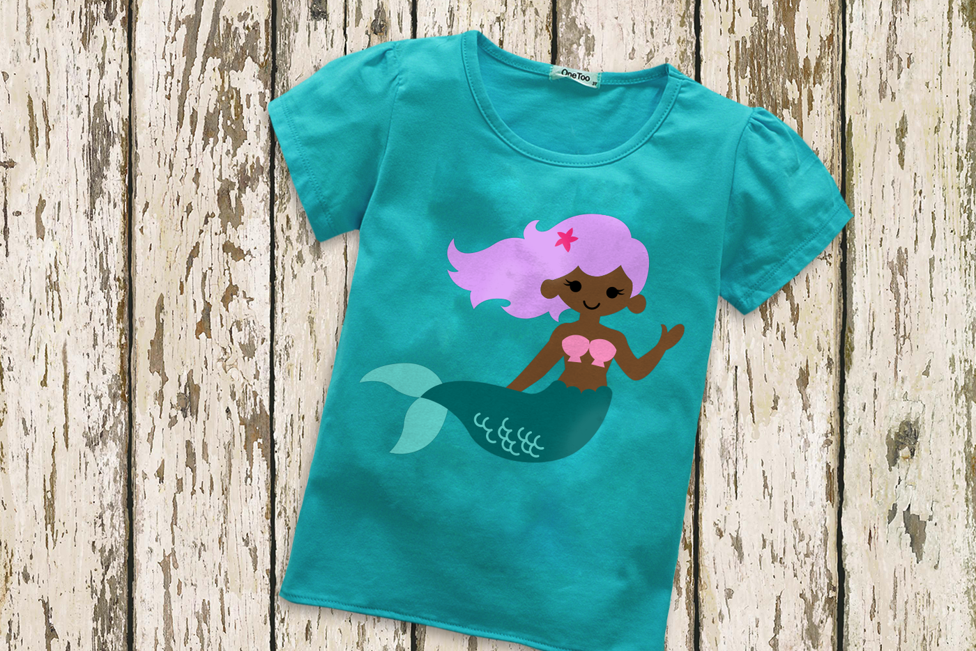 A turquoise child's tee with a black mermaid with lavender hair and a teal tail.