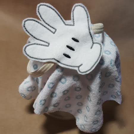 A large white cartoon glove made of felt and attached to an elastic headband.