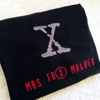 Large embroidered X with the words "Mrs Fox Mulder" below