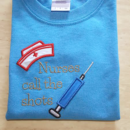 Applique nurse hat and syringe with the words "Nurses call the shots"