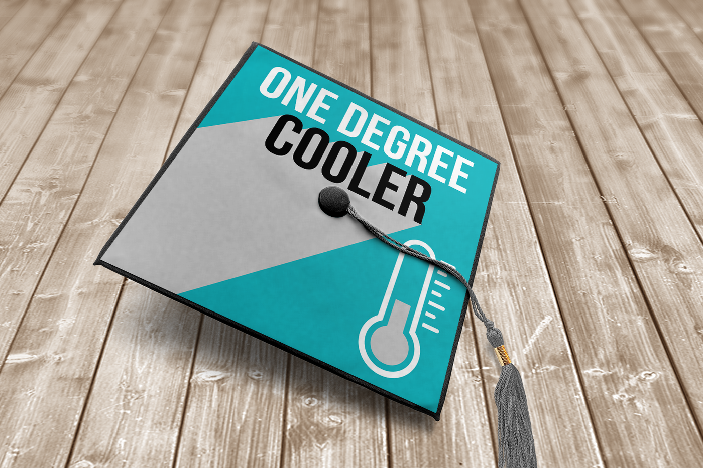 Graduation cap design that says "one degree cooler" with a thermometer.