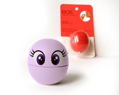 An EOS brand lip balm container in lavender with large purple cartoon eyes. An unopened lip balm is in the background, out of focus.