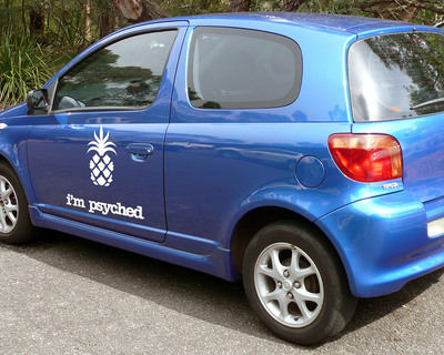 Blue car with a decal of a pineapple and the words "I'm psyched."