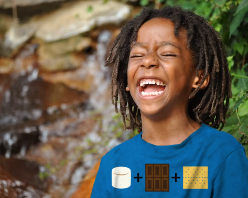 Laughing black boy wears a shirt with the image of a marshmallow + a chocolate bar + a graham cracker