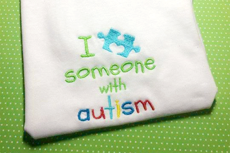 Embroidery design that says "I heart someone with autism." The heart is a puzzle piece with a heart shape for one of the notches.
