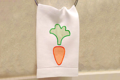 A white tea towel with a cute carrot applique.